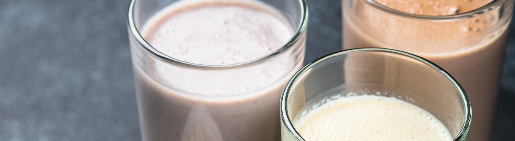 3 different flavored protein shakes in glasses.