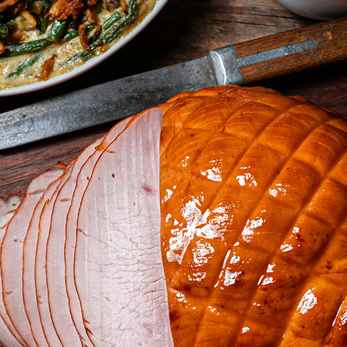 Assortment of holiday food on a table, including turkey, pumpkin pie, and casserole dish.