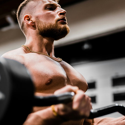 Man curling 60-pound bar at the gym.